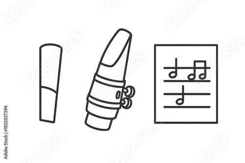 Clarinet mouthpiece, reed, and sheet music placed on a table for a music practice session indoors