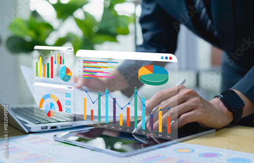 Businessman interacting with virtual screen showing business growth and investment graphs, strategic planning for sales increase and long term profit optimization.