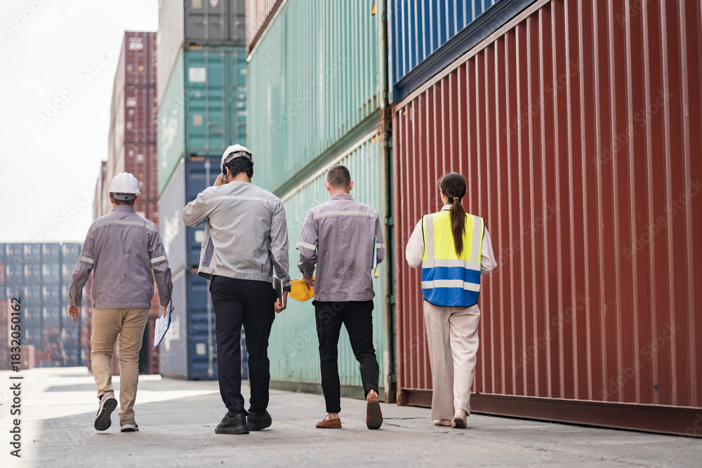 Fototapeta premium Back engineer walking and worker team working in logistic terminal of container cargo, Diverse construction team in safety gear outdoors 