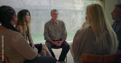 Foto Middle aged man sharing emotional testimony during therapy group session, partic