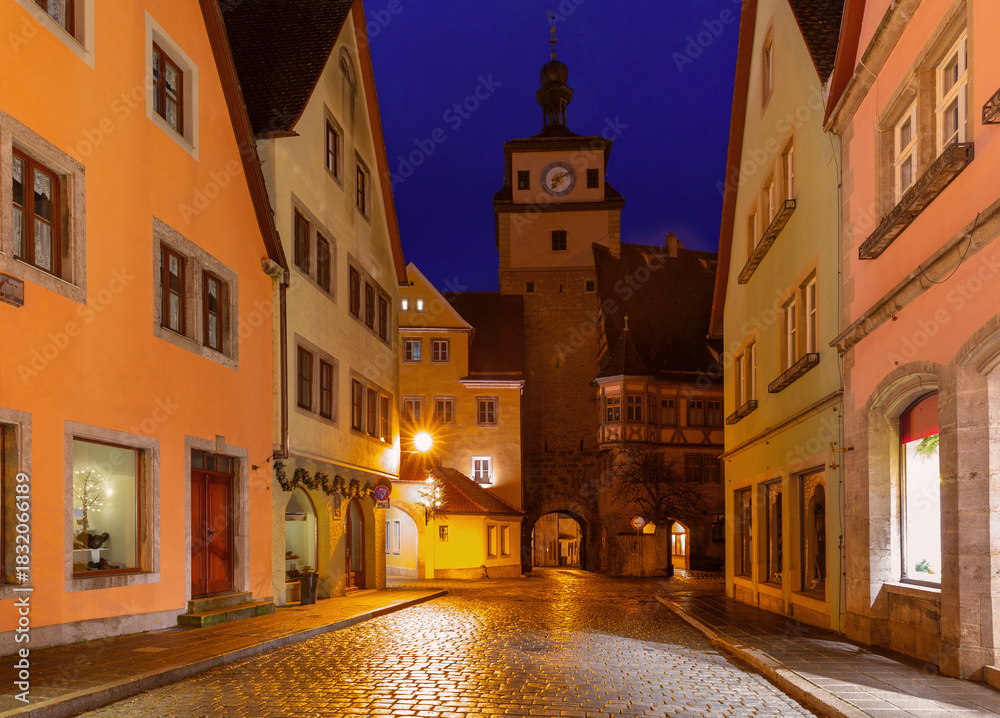 Fototapeta premium Markus Tower and Roeder Arch in Rothenburg ob der Tauber Germany illuminated at night with historic houses