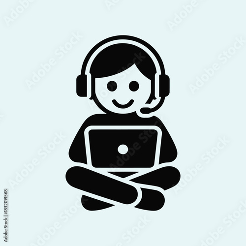 person wearing headphones sitting cross legged using a laptop computer illustrating relaxed digital work environment remote learning habits modern communication culture freelance workflow and youth 