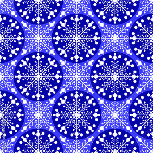 Falling snowflakes against a blue sky. Snowy decorative background. Abstract geometric seamless pattern in white and blue. Vector pattern.