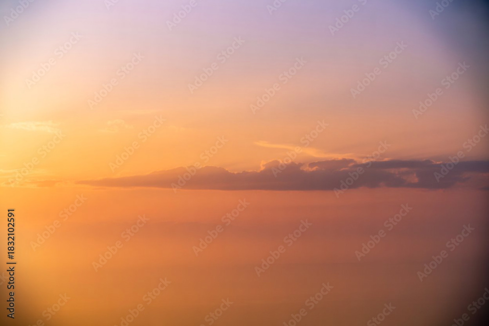 Naklejka premium Soft sunset sky with wispy clouds and warm hues