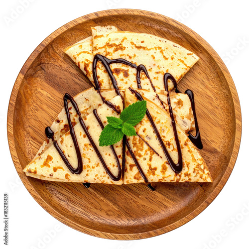 Stacked, folded thin pancakes with chocolate drizzle, mint, on a wooden plate
