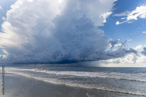 A large thunderstorm builds off the Atlantic coast of South Carolina over the beach.