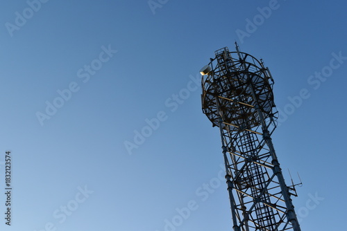 Looking up at a mobile phone tower on a sunny day.