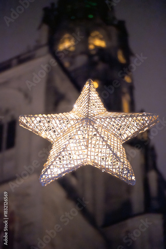 During the Christmas season, illuminated stars hang in front of the Münster unserer lieben Frau's illuminated tower walls, which shine at night. Constance, Baden-Württemberg, Germany.