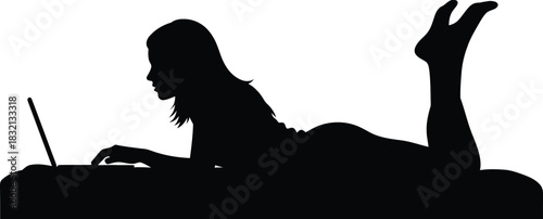 Silhouette of a woman lying down using a laptop