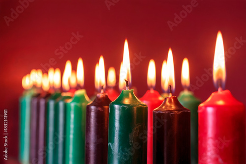 Colorful Tall Candles Burning in a Row Against Warm Red Background