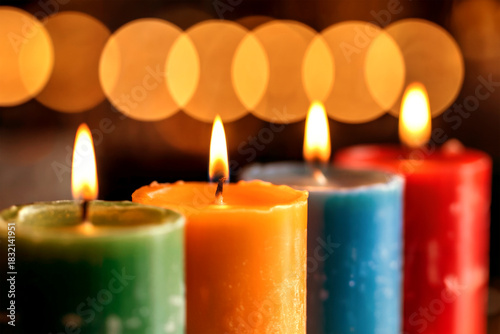 Colorful Burning Candles with Warm Golden Bokeh Background