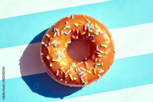 Colorful Sprinkled Donut on Bright Striped Background