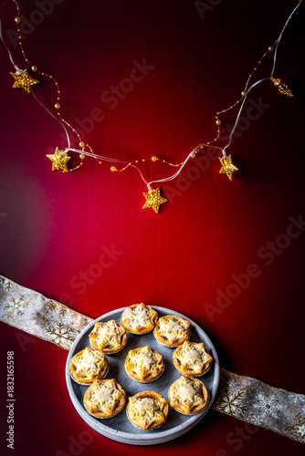 Christmas mince pies on a deep red background with Christmas lights