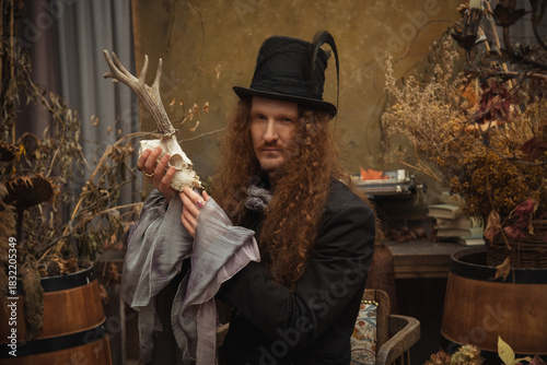 Wallpaper Mural Man with long hair holding an antler skull in a stylish room Torontodigital.ca