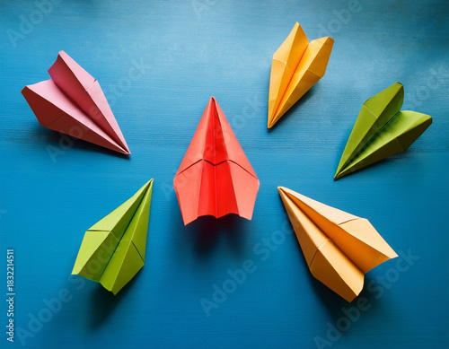 Colorful Origami Paper Airplanes Thematically Arranged On a Vibrant Turquoise Surface