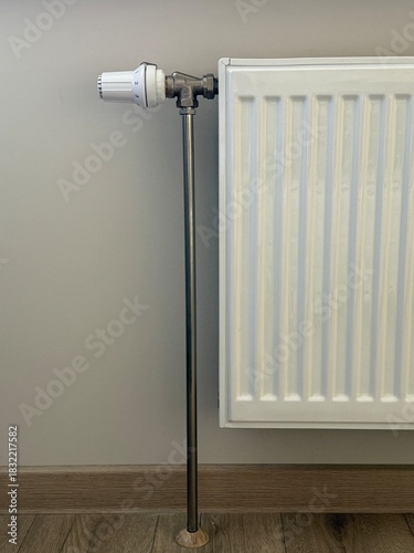 Wallpaper Mural White steel radiator on the background of a beige wall.
The heating level is regulated by a handle. The option of heating a house or apartment. Torontodigital.ca