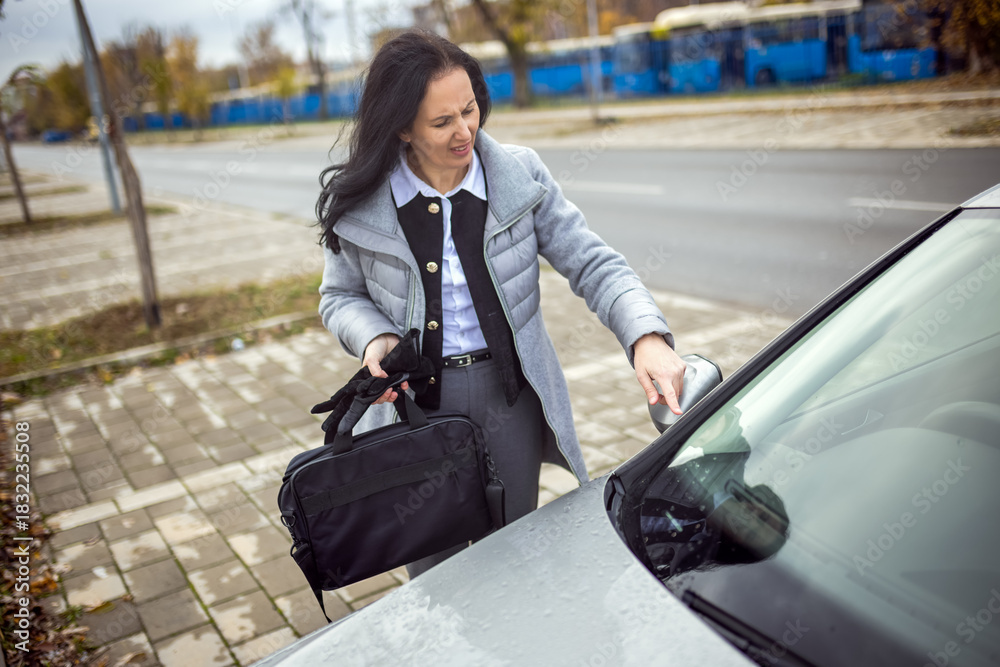 Fototapeta premium Woman inspecting scratches on car