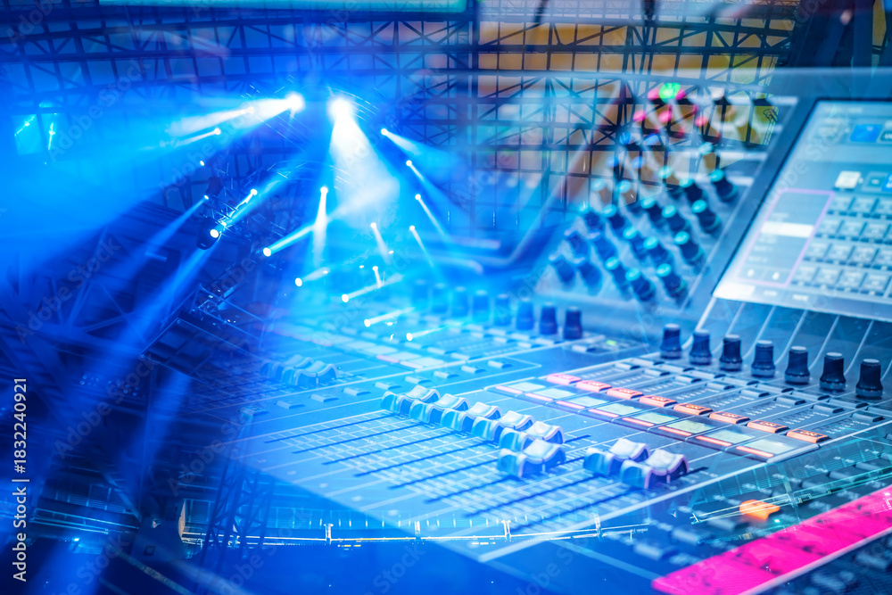 Naklejka premium Stage audio engineering involves operating a digital mixing console to control sound levels and effects during live events enhanced by professional lighting systems.
