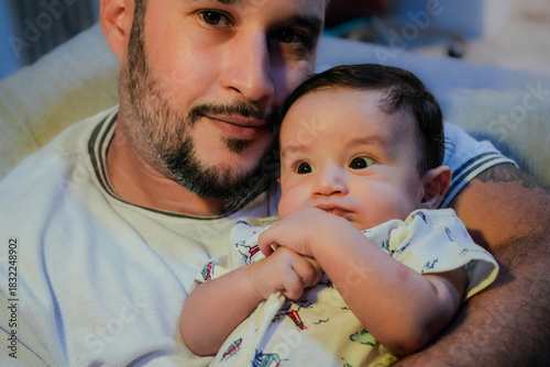 Mexican modern father with his new born baby, indoors lighting