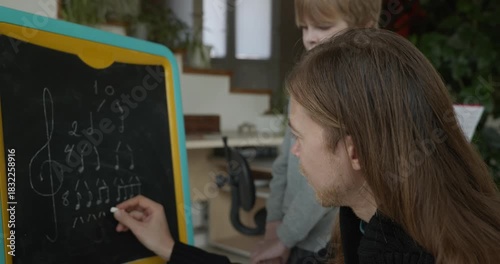 Male Teacher Gives Music Lesson for a Child. Man is Teaching Kid to Play Musical Instrument. 4K 10-bit