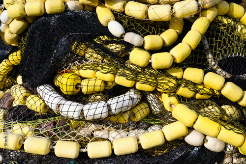 Commercial industrial fishing net istored n flowing pattern with yellow floats in closeup