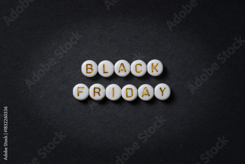 Black Friday text made of round beads in gold letters on black paper, advertising banner with space for text. High-resolution photo. Discount cards.
