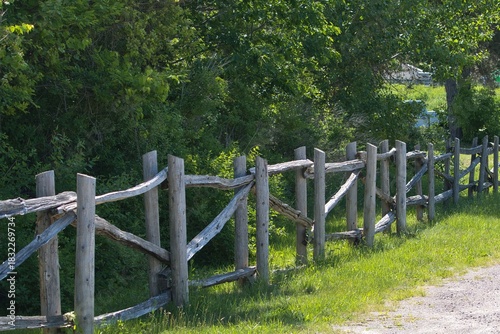 Old style wooden fence alongside a tree line.