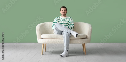 Happy young man sitting on ...