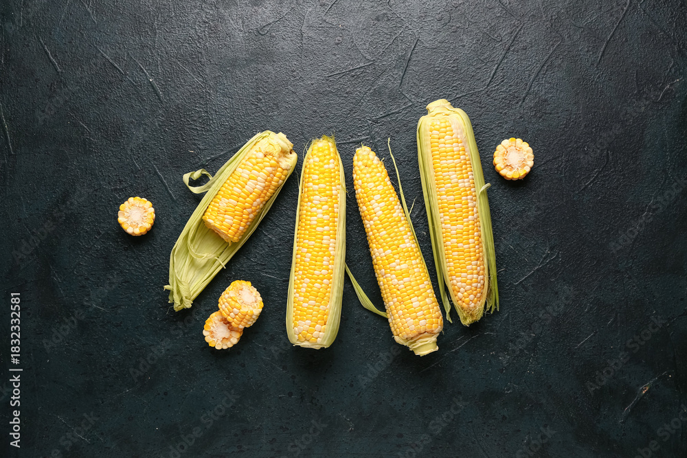 Fototapeta premium Fresh corn cobs on black background