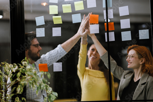 Collaborative brainstorming session in a modern office with colorful sticky notes on the wall