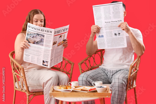Young couple reading newspa...