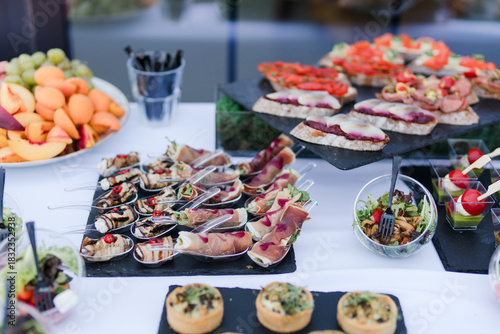 Catering banquet table at reception. Restaurant presentation, european cuisine, food consumption, party concept. Food styling, appetizers bar, welcome drink, event design.