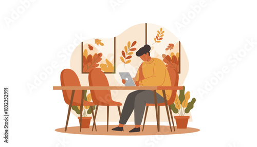 Cozy remote work Woman using tablet at a table with autumn leaf decor
