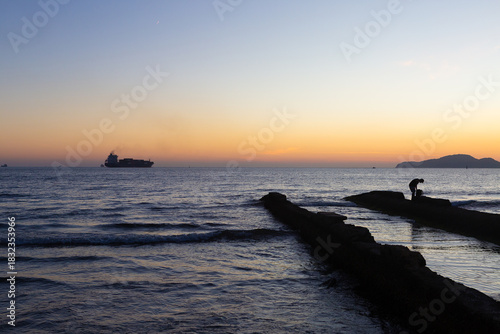 Sunset at Canal 5 in Santos with cargo ship on the horizon
