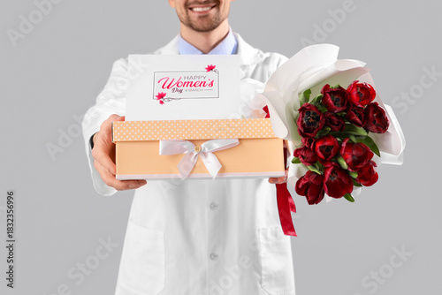 Happy male doctor with bouq...