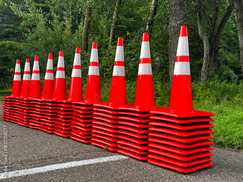 Ten tacks of orange and white plastic traffic cones lined up in a row.