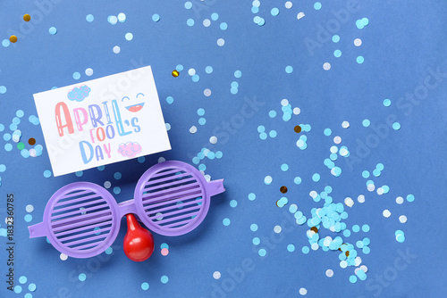 Festive postcard for April Fools Day with funny glasses and confetti on blue ...