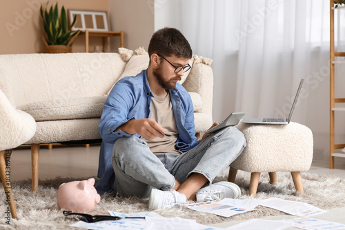 Young man in debt with calc...