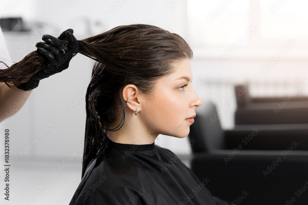 Fototapeta premium Young caucasian female getting hair treatment in salon