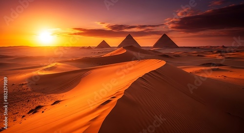 Golden sunset over desert landscape with pyramids in the distance and sand dunes