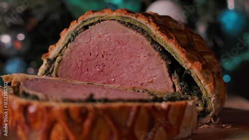 Panoramic shot of Beef Wellington on a table with Christmas decorations, candles and spruce branches during holiday dinner