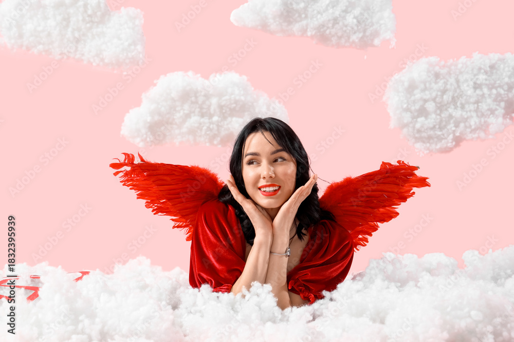 Fototapeta premium Beautiful young happy woman dressed as cupid lying in clouds on pink background. Valentine's Day celebration