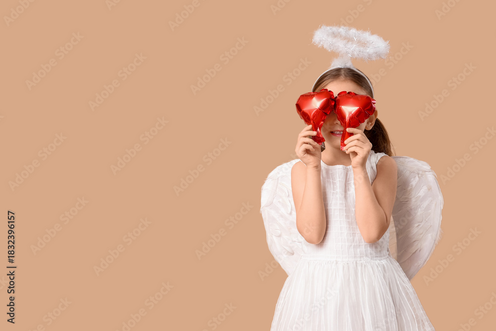 Obraz premium Cute little girl dressed as Cupid with air balloons in shape of heart on brown background. Valentine's Day celebration