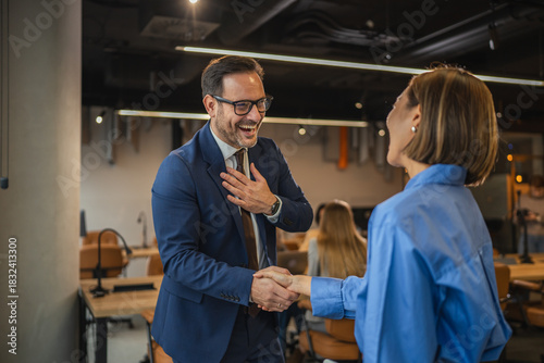 Smiling business colleagues enjoying a casual conversation in the office