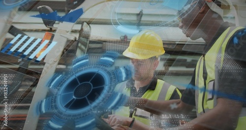 Reviewing handheld tablet two workers in high-vis vests and yellow hardhat at factory, AR graphics
