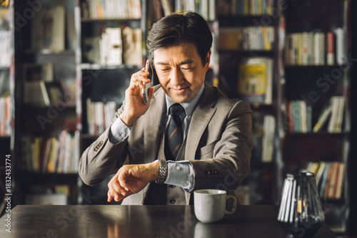 Canvastavla Asian male businessman checking his watch in the library, study (appointment, sc