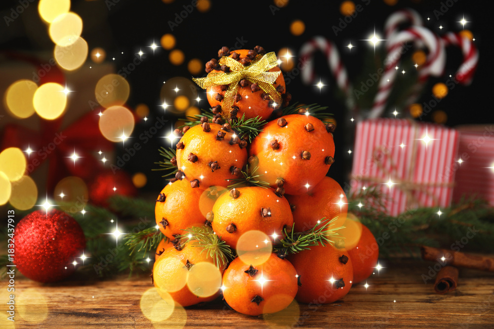 Fototapeta premium Christmas tree made of tangerines with cloves on table. Bokeh lights