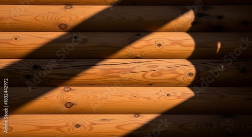 Sunlight streams across a cabin wall, showcasing the textures and warm tones of the wooden logs.