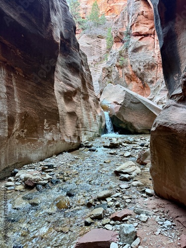 Kanarra Falls hiking trail. Kanarraville, Utah. Gorgeous canyoneering river hike. waterfalls and slot canyons. Next to Kolob Canyon, Zion national park. Ankle to knee deep water. Red rock mountains. 