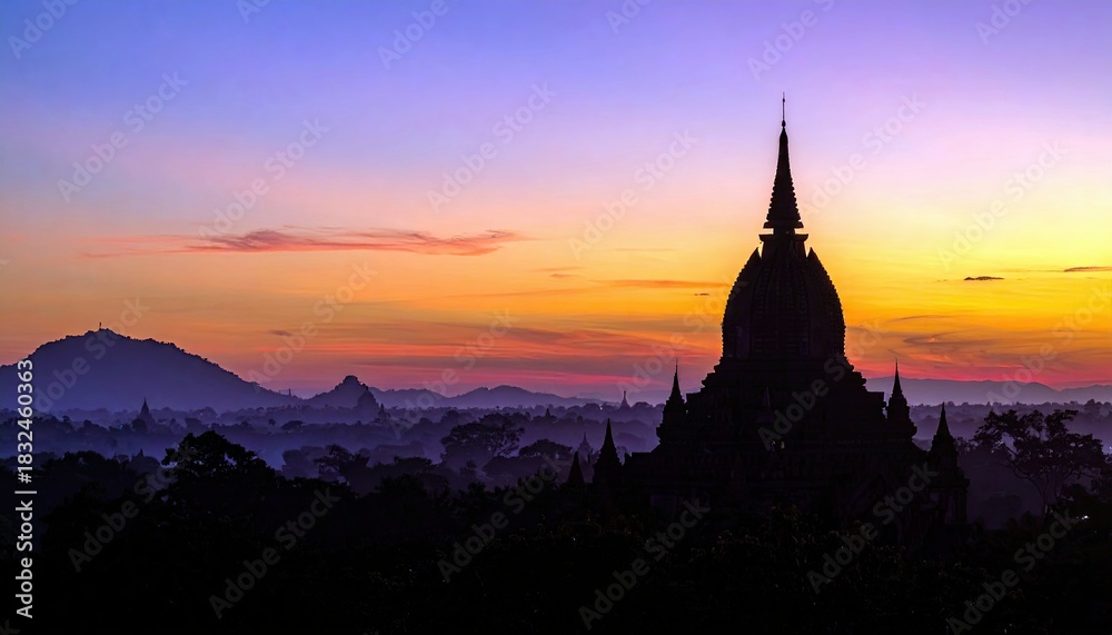 Obraz premium A silhouette of a pagoda against a vibrant sunset in Bagan, Myanmar. The image captures the beauty of the landscape with a colorful sky and the ancient architec
